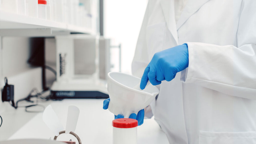 hands of a compound pharmacist mixing medication